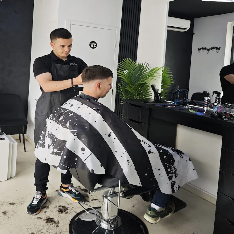 Barber šiša muškog klijenta mašinicom u Barber Studio 7 u Nišu